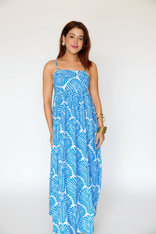 Woman in a blue dress standing in a living room.